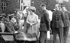 A royal visit. Queen Elizabeth (the Queen Mother) talks to patients with Lady Salisbury in the background.