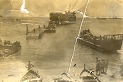 Pontoon bridge being constructed from a landing craft to the shore. From the papers of Jim Williams.
