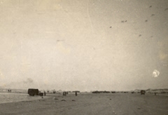 Dunkirk beach, Friday 31 May 1940. A/A shells bursting top right corner. British troops still waiting. L Barter. 