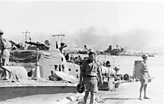 Tobruk Harbour - The tension can be seen in the photo! The Motor Mechanic (right of picture) and the torpedoman shielding his gaze are scanning the skies for the everpresent Stukas: the Coxswain carries his tin hat -in case.