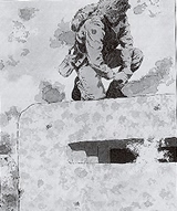 Company Sergeant-Major Stan Hollis of 'D' Company, 6th Green Howards clambers on top of the enemy pillbox. Courtesy of The Green Howards Regimental Museum.